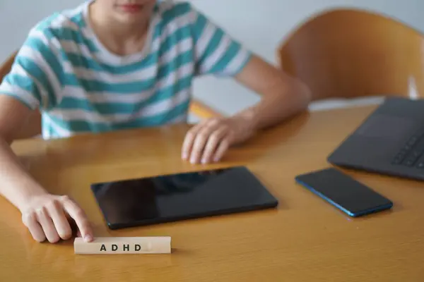Adhd ve teknoloji. Tıbbi kavramlar. Bazı aygıtları olan ve kısaltmayı işaret eden çocuk