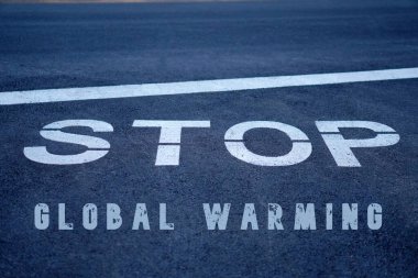 Küresel ısınma kavramını durdur Yol işareti ve asfaltta yazan mesaj.