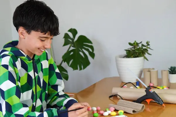 Ekransız eğlence konsepti. reşit olmayan çocuk geri dönüşümlü malzemelerle resim ve zanaat yapmayı seviyor.