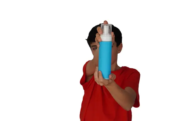 Çocuklarda cilt bakımı. Genç çocuk kameraya cilt bakımı için bir şişe yüz sabunu gösteriyor..