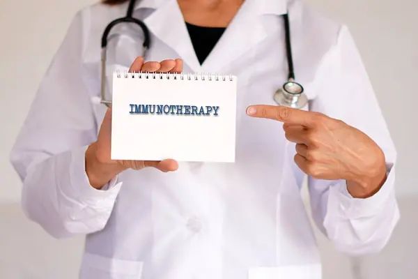 Bağışıklık terapisi. Tıbbi kavramlar. Kadın doktor, defterde yazan sözcüğü işaret ediyor..