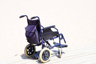 Maluliyet dostu tatiller. Tekerlekli sandalye plajdaki ahşap platformda.