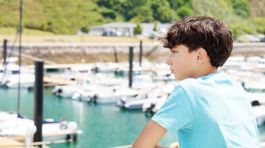 İspanya sahillerinde yaz tatili boyunca limanda dalgın genç bir çocuğun portresi.