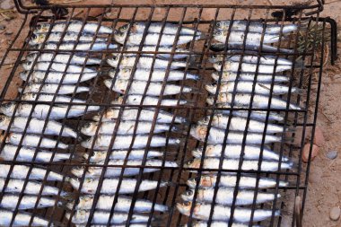 Tatiller ve plajda barbekü. Izgara sardalya yapmak için hazırlanmış sardalyeli ızgara.