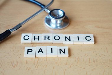 Tıbbi konsept görüntüsü kronik acıyı temsil ediyor. Yanlarına steteskop yerleştirilmiş hafif bir yüzeyde 