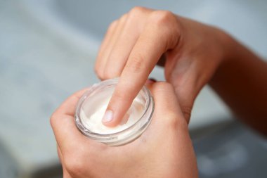 Sabah rutinleri. Gençlerin elleri, tenlerine sürmek için kavanozdan nemlendirici alıyor..