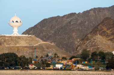 A beautiful landscape view of Riyam Park in Muscat, Oman. The vibrant park is surrounded by rolling hills and offers a peaceful escape in the heart of the city. clipart