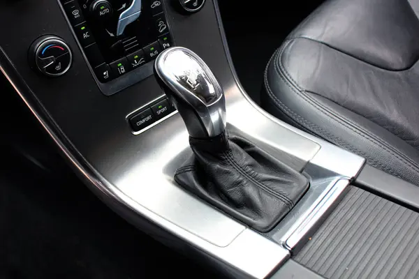 Modern arabanın içinde otomatik vites var. Otomatik vites kutusu kolu. Arabadaki otomatik vites kolunun ayrıntıları. Deri iç mimari modern SUV..