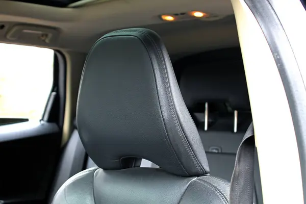Leather headrest in luxury car interior. Car seat headrest. Interior detail.