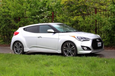 Vinnytsia, Ukrayna; 25 Nisan 2024. Gri Hyundai Veloster yağmurlu havada şehir caddesinde. Hyundai Veloster park yerinde. Sağ ön görünüm.