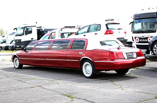 Vinnytsia, Ukrayna; 20 Nisan 2024. Kırmızı gerilmiş limuzin Lincoln Town Car. Şehir caddesi. Park yerinde klasik Amerikan arabası Lincoln Town Car. Arka görünüm.