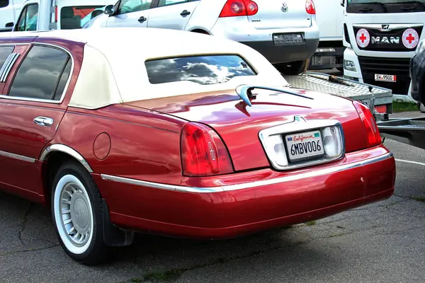 Vinnytsia, Ukrayna; 20 Nisan 2024. Kırmızı gerilmiş limuzin Lincoln Town Car. Şehir caddesi. Park yerinde klasik Amerikan arabası Lincoln Town Car. Arka görünüm.