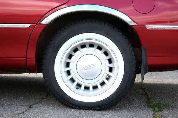 Vinnytsia, Ukrayna; 20 Nisan 2024. Kırmızı limuzin Lincoln Town Car 'ın arka tekerleği. Klasik Amerikan arabası Lincoln Town Car wheel.