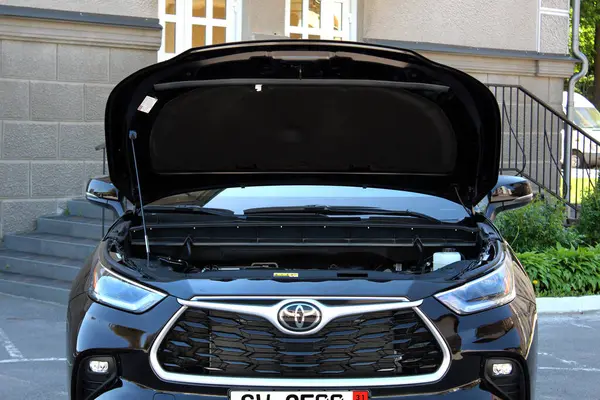 Vinnytsia, Ukrayna; Mayıs 04, 2024. Siyah Toyota Highlander 2023 açık kaput. Japon SUV Toyota Highlander gaz motoru. Kapüşonlu bozuk motor Toyota Highlander. Ön görünüm.