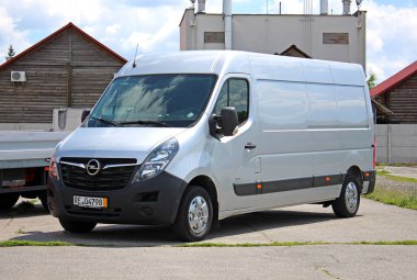 Vinnytsia, Ukrayna; 21 Mayıs 2025. Cargo van Opel Movano Maxi şehir caddesinde. Kargo Van Renault Ustası park yerinde. Hafif ticari araç Grey Opel Movano. Malların teslimatı. Sağ ön görünüm.
