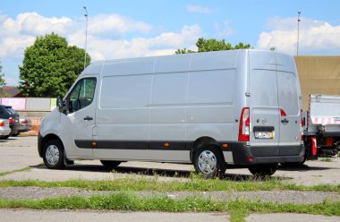 Vinnytsia, Ukrayna; 21 Mayıs 2025. Cargo van Opel Movano Maxi şehir caddesinde. Kargo Van Renault Ustası park yerinde. Hafif ticari araç Grey Opel Movano. Malların teslimatı. Arka sol görünüm.