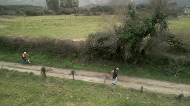 Sırt Çantasıyla Dağlarda Birikintisi Yolda Yürüyen Yeşil Bisikletli Bir Insanı — Stok video
