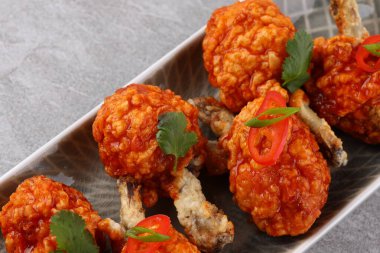 Baharatlı ve sebzeli ızgara tavuk kanadı beyaz arka planda yatıyordu..