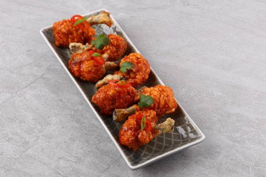 Baharatlı ve sebzeli ızgara tavuk kanadı beyaz arka planda yatıyordu..