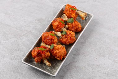 Baharatlı ve sebzeli ızgara tavuk kanadı beyaz arka planda yatıyordu..