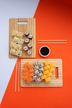 Sushi teslimatı. Siyah arka planda tek kullanımlık bir kutuda rulo. Üst görünüm,