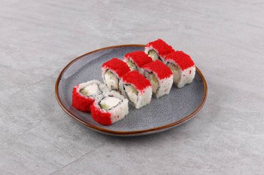 Top view of portion of Japanese sushi roll with salmon, avocado, cream cheese and caviar on top. Dish with chopsticks isolated on black background with text and copy space. Ready advertising banner