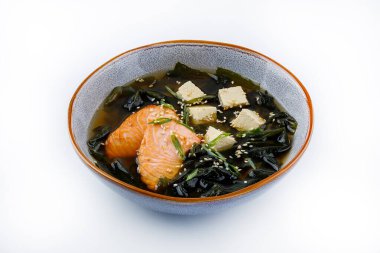 Japon miso çorbası, somon balığı, tofu ve deniz yosunuyla birlikte koyu bir arka planda. Üst görünüm
