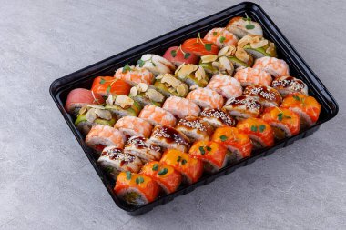 Japon suşi dürümleri, suşi seti restoran menüsü ve yemek teslimatı için gri bir arka plan.,