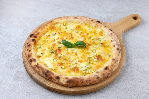 Eritilmiş peynirli beyaz pizza, ballı, şam fıstığı ve taze fesleğen..
