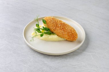 Patates püresi ve tereyağlı taze bezelye filizli Kiev usulü tavuk..