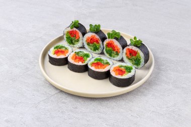 Baharatlı yosun salatası, doğranmış havuç ve kırmızı dolma biberle doldurulmuş Norveç usulü suşi ve suşi pilavına sarılmış vejetaryen maki dürümü..