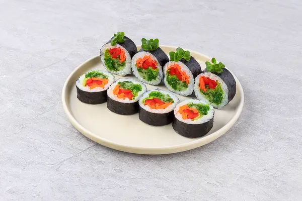 Baharatlı yosun salatası, doğranmış havuç ve kırmızı dolma biberle doldurulmuş Norveç usulü suşi ve suşi pilavına sarılmış vejetaryen maki dürümü..