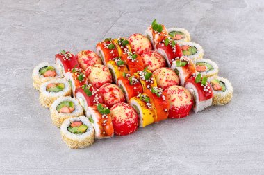 Somonlu avokado rulo ton balıklı krem peynirli peynir ve mikroyeşillik ve çıtır incilerle kaplı susam kabuklu parçalardan oluşan renkli Kaliforniya suşi seti. Paylaşım ve suşi geceleri için ideal..