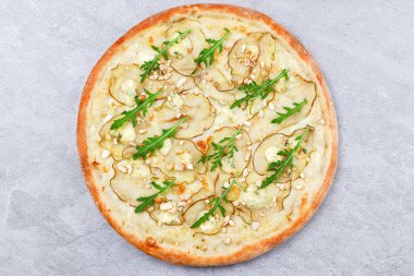 İnce armut dilimli beyaz soslu pizza, kremalı mavi peynir parçaları, kızarmış badem parçaları ve taze roka rafine edilmiş tatlı ve lezzetli bir lezzet deneyimi için.