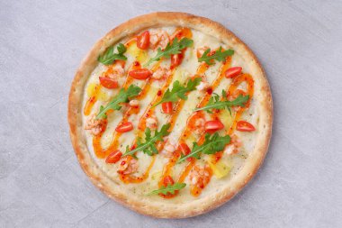 Lezzetli karides, tatlı ananas, taze roka, vişneli domates, kremalı beyaz sos ve baharatlı acı biber yağlı çiseleme ile kaplı bir gurme ince hamurlu pizza her ısırıkta nefis, tatlı ve sıcak bir denge sağlar.