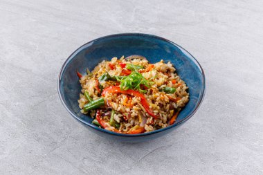 Canlı, tavada pişirilmiş biber, yeşil fasulye, havuç, soğan ve soğan dolu bir pirinç kasesi çıtır çıtır, sağlıklı bir vejetaryen ziyafeti için kızarmış susam tohumuyla son buldu..