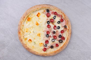 Bir tarafında kremalı quattro formaggi, diğer tarafında lezzetli jambon, zeytin ve pepperonili yarım pizza, çıtır çıtır bir kabukta altın mükemmelliğinde pişirilmiş..