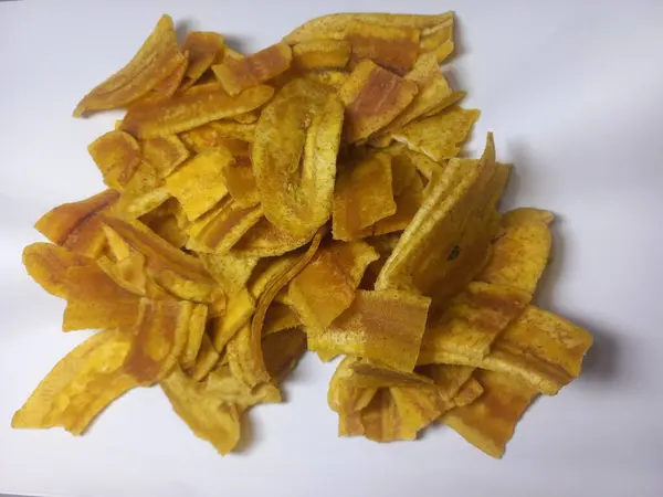 Beyaz arka planda izole edilmiş muz cipsleri, yakın plan, kopyalama alanı, seçici odak. Tatlı ve çıtır çıtır. Ürün, reklam ve aşçılık blogu için gıda fotoğrafçılığı kavramı.