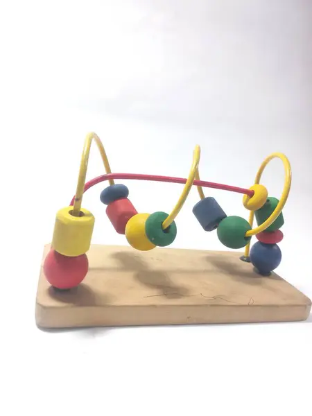 Beyaz arka planda küçük boncuklarla dolu ahşap labirent. Çocukların motor becerilerini geliştirmeleri için renkli bir oyuncak..