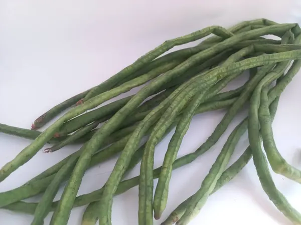 Beyaz arka planda uzun taze fasulyeler. Kapatın. Seçici odaklanma. Uzayı kopyala Birçok faydası olan sağlıklı sebzelerin konsept fotoğrafı.