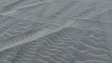 Plajdaki kumda lastik izleri ve ayak izleri..