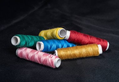 Koyu arkaplanda renkli dikiş iplikleri, yakın plan