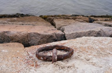 Deniz kıyısındaki kayalarda paslı çapa zinciri