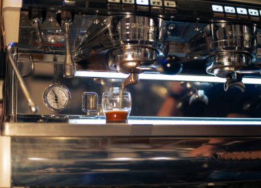 Bir kafede kahve makinesi müşteriye kahve hazırlıyor.