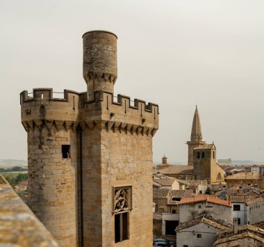 Arka planda kilise kulesi olan eski bir kale kulesi.