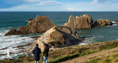 Liencres, Cantabria (İspanya); 10 Mart 2024: İspanya 'nın kuzeyindeki nadir görülen sinek oluşumunun doğal parkını ziyaret eden insanlar. Costa Quebrada Doğal Parkı