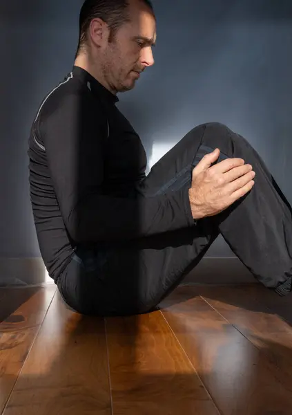 Adam evde oturup karın kasları çalışıyor.