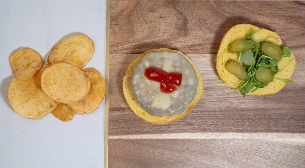 Salatalık, roka, peynir, domates ve cips ile yapılmış bir ev manzarası.