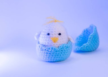 Açık mavi arka planda yumurtalı mavi örülmüş tavuk. Paskalya kartı.