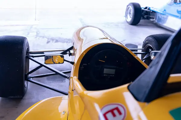 Sarı formüllü araba kokpiti garajda.